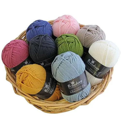 Basket of colorful yarn balls with labels on a white background